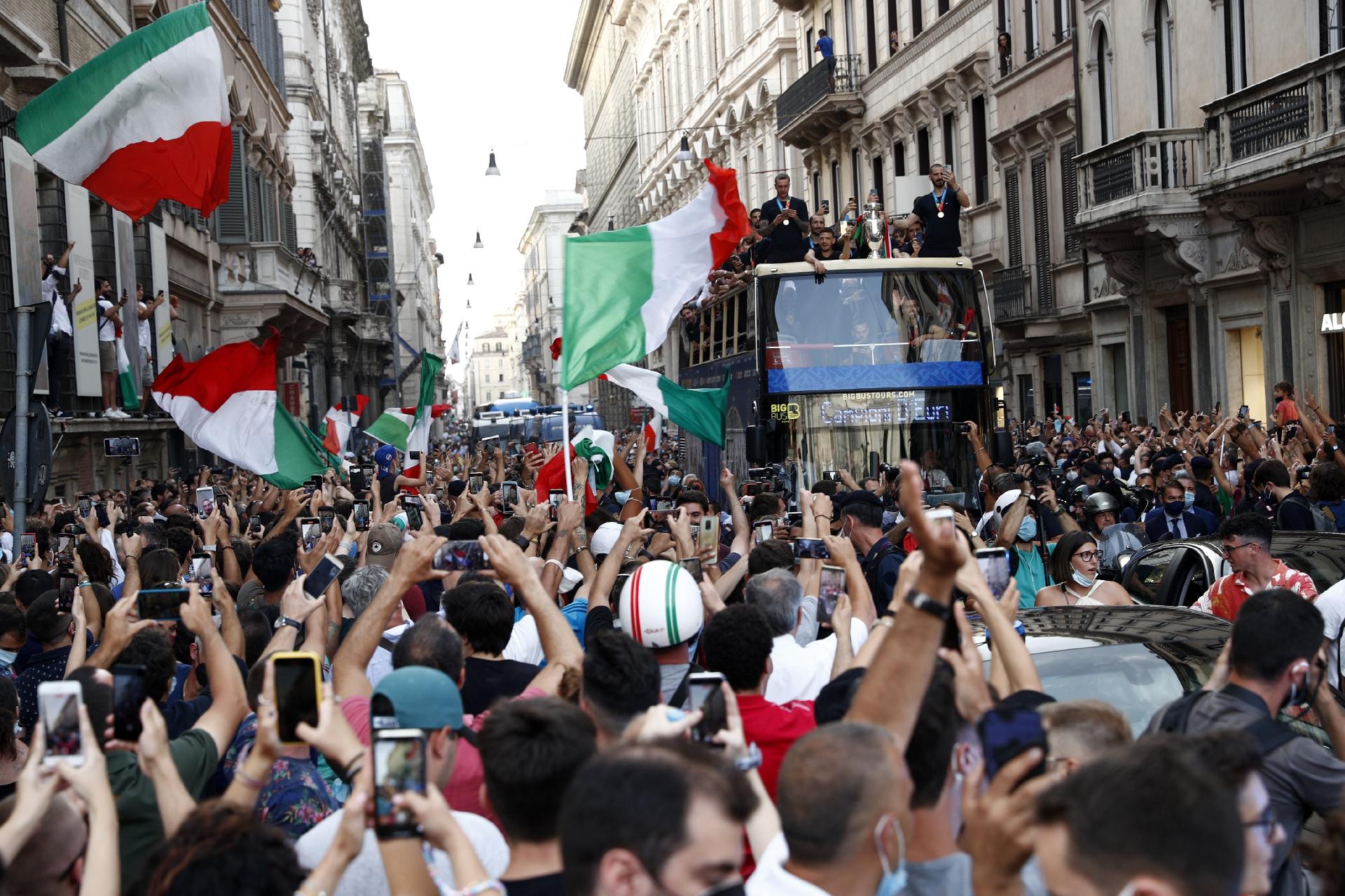 Soccer Football - Euro 2020 - The Italy team drive through Rome on a open top bus tour after they won Euro 2020 - Rome, Italy - July 12, 2021 Fans celebrate as Italy's players react on the bus during the tour REUTERS/Guglielmo Mangiapane - GUGLIELMO MANGIAPANE/REUTERS
