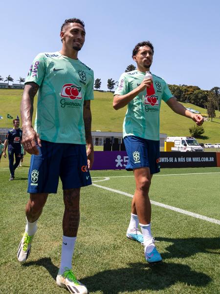 Raphinha e Marquinhos caminham para o campo de treino da seleção brasileira na Granja Comary