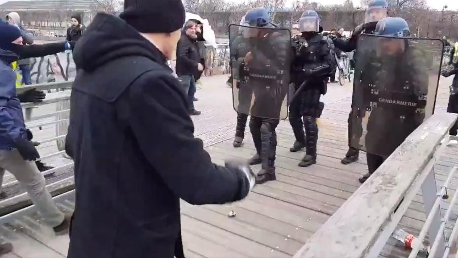 Ao lado de "coletes amarelos", pugilista profissional desferiu socos no capacete e no escudo de policial - Twitter/LinePress