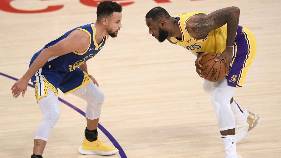 LeBron James, do Los Angeles Lakers, enfrenta a marcação de Stephen Curry, do Golden State Warriors - NBAE Harry How/Getty Images/AFP