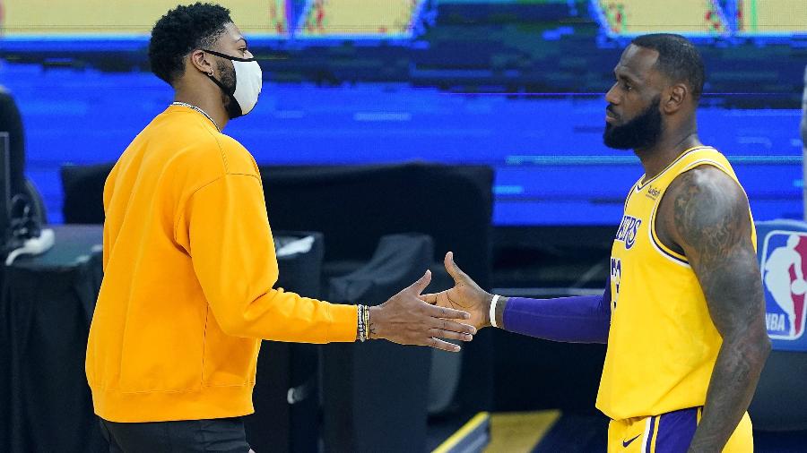 LeBron James e Anthony Davis, do Los Angeles Lakers, se cumprimentam durante jogo da NBA - Thearon W. Henderson/Getty Images/AFP
