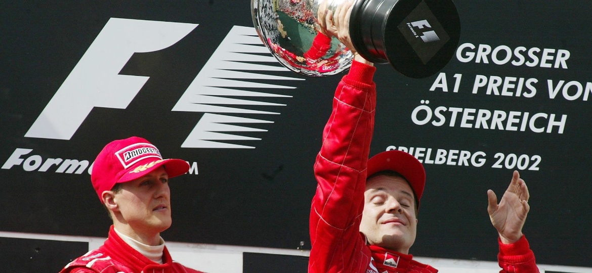 Schumacher empurra Barrichello para o primeiro lugar do pódio no GP da Áustria de 2002. Brasileiro ficou em segundo após frear a poucos metros do final e deixar Schumacher vencer a prova depois de ordem da Ferrari - Diether Endlicher-12.mai.2002/AP