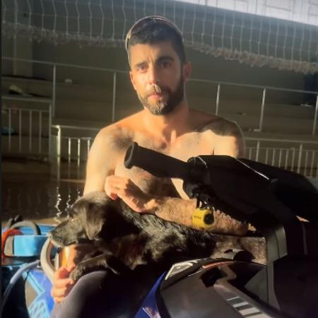 Pedro Scooby com um cachorro resgatado em um ginásio no Rio Grande do Sul