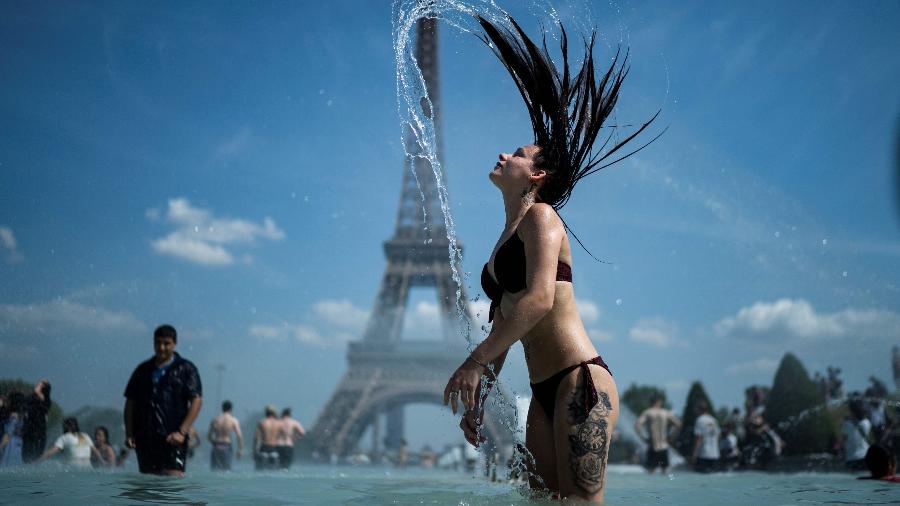 Mulher se banha nas águas da Esplanada do Trocadero com a Torre Eiffel ao fundo - Kenzo Tribouillard/AFP