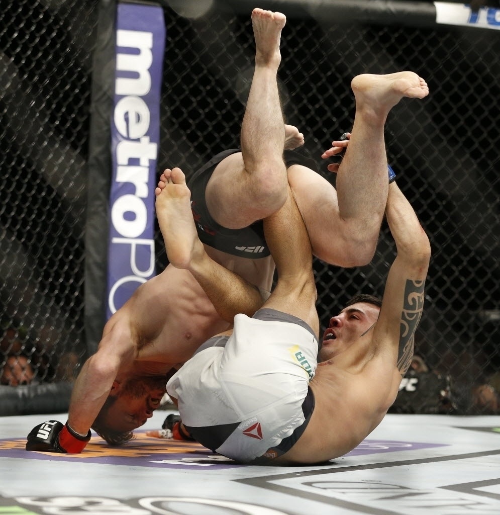 Thomas Almeida (dir.) e Brad Pickett disputam posição no chão, durante primeiro round da luta; o brasileiro venceu por nocaute, na primeira luta do card principal do UFC 189, neste sábado (11) - John Locher/AP Photo