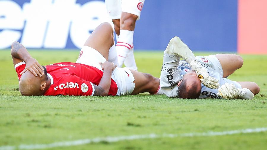 Rodrigo Moledo e Marcelo Lomba ficam caídos após choque durante a partida entre Internacional e CSA - Pedro H. Tesch/AGIF
