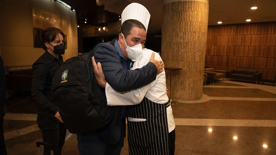 André Jardine abraça o chef de cozinha Jaime Maciel na chegada da seleção ao Equador - Lucas Figueiredo/CBF