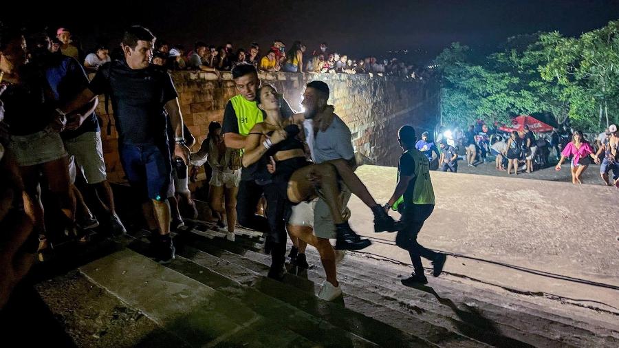 Homens carregam uma das vítimas de tiroteio ocorrido durante o Ja"umina Fest em San Bernardino (Paraguai).  Cristina Vita Aranda, mulher do jogador do Olimpia foi uma das vítimas - EFE