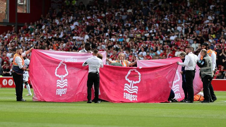 Funcionários estendem panos em volta de Danilo, do Nottingham Forest, enquanto jogador é atendido após sofrer grave lesão em jogo contra Bournemouth