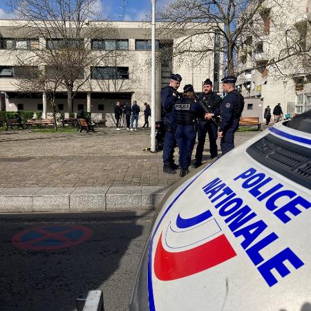 Polícia e jornalistas do lado de fora da delegacia de polícia de La Courneuve, um subúrbio ao norte de Paris