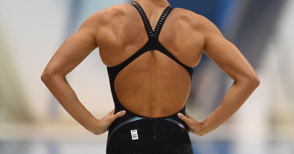 Natalie Coughlin é fotografada de costas antes de cair na água para as eliminatórias dos 100 m livre da natação