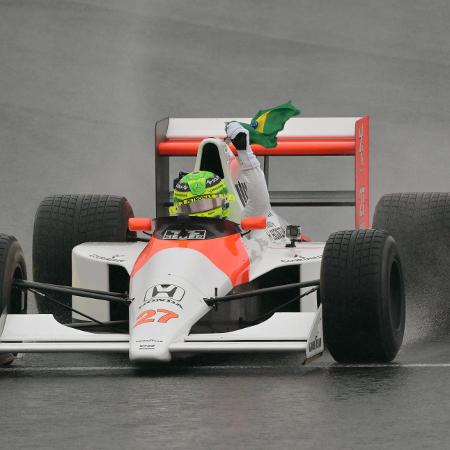  Lewis Hamilton exibe a bandeira do Brasil pilotando o carro da McLaren de Ayrton Senna no GP de SP