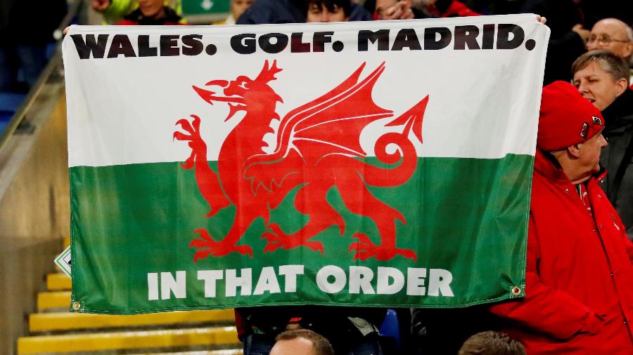 Torcedores seguram a bandeira com os dizeres "Gales. Golfe. Madrid. Nessa ordem" - ANDREW BOYERS / REUTERS