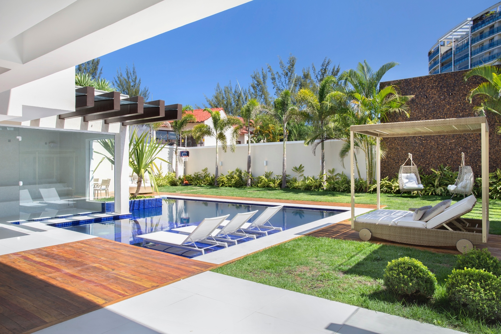 A casa do meia-atacante Alex Teixeira no Rio de Janeiro tem piscina espaçosa com espreguiçadeiras na 'prainha', cadeiras e balanço e uma parede feita toda em mosaico de pedrinhas para dar menos visibilidade à casa do vizinho - Divulgação