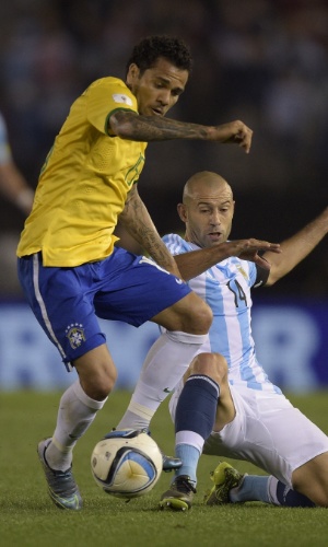 Daniel Alves disputa bola com Mascherano na partida do Brasil contra a Argentina pelas Eliminatórias