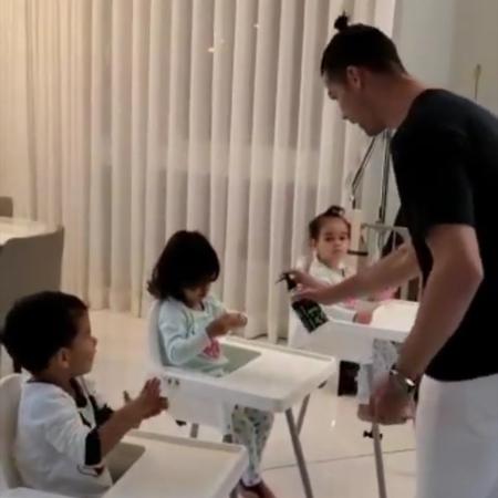 Cristiano Ronaldo espirra álcool em gel nas mãos dos filhos - Reprodução/Instagram