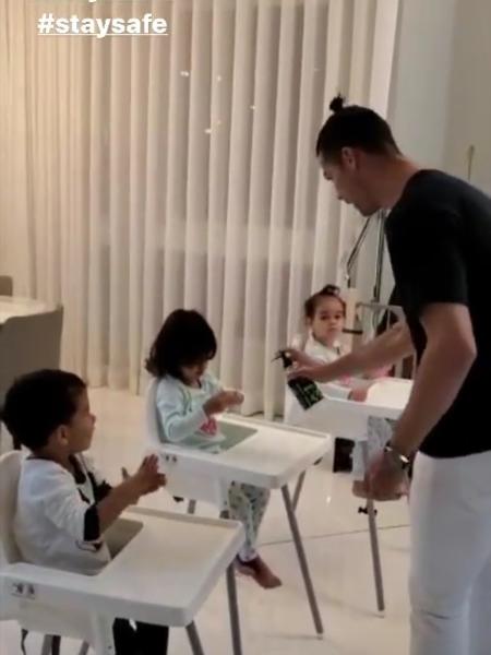 Cristiano Ronaldo espirra álcool em gel nas mãos dos filhos - Reprodução/Instagram