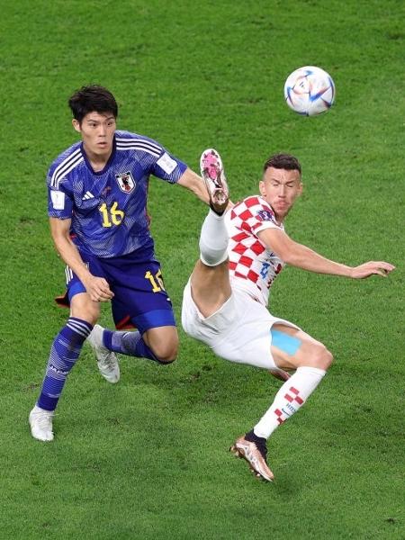 Perisic, que fez o gol da Croácia no empate em 1 a 1 com o Japão no tempo normal, disputa lance com Tomiyasu - Elsa/Getty Images