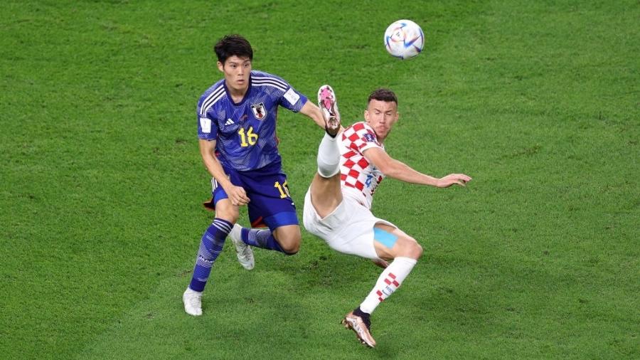Perisic, da Croácia, disputa lance com Tomiyasu, do Japão, durante a partida das oitavas de final da Copa do Qatar - Elsa/Getty Images