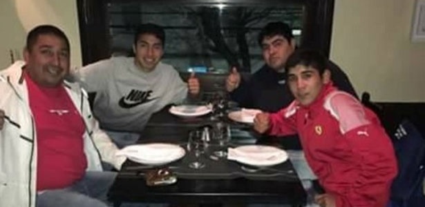Luciano (ao fundo) e seu pai Juan Oscar em jantar com amigos no dia do crime - Reprodução/Facebook