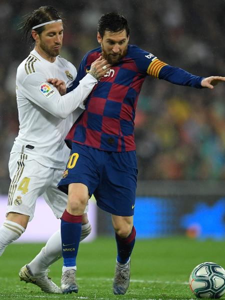 O zagueiro Sergio Ramos, do Real Madrid, e Messi, do Barcelona, em lance pelo clássico do Campeonato Espanhol - OSCAR DEL POZO / AFP