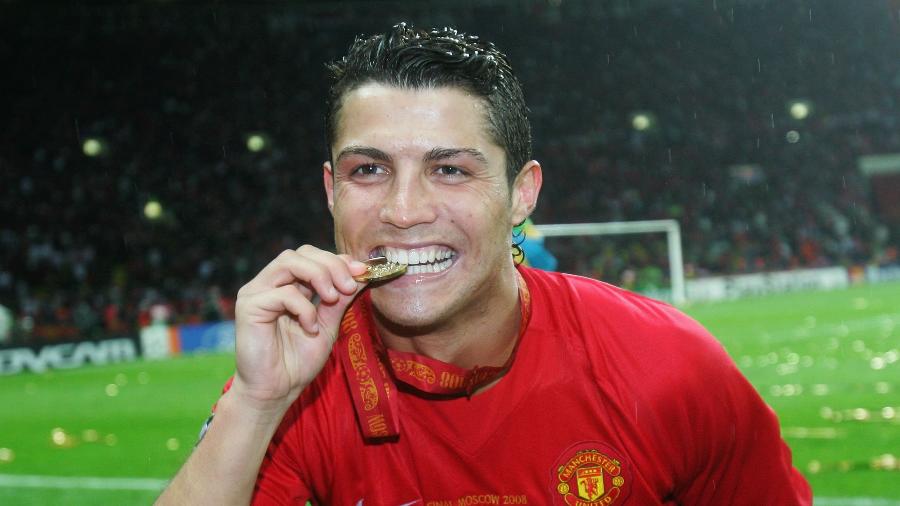 Cristiano Ronaldo morde a medalha de campeão da Liga dos Campeões da Europa de 2008, com o Manchester United - Alex Livesey/Getty Images