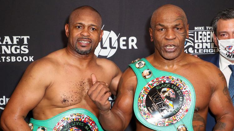 Roy Jones Jr e Mike Tyson com cinturões após luta em Los Angeles