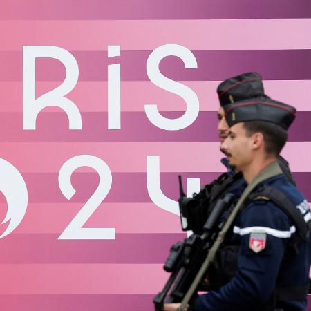 Policiais franceses perto do logotipo dos Jogos Olímpicos de Paris 2024