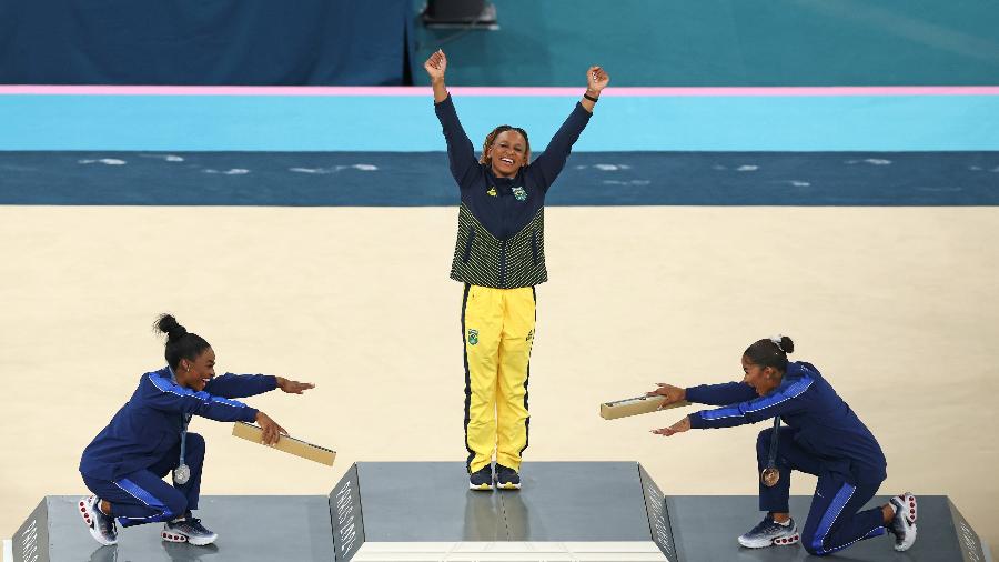 Rebeca Andrade recebe reverência de Simone Biles e Jordan Chiles no pódio do solo em Paris 2024. Rebeca levou o ouro olímpico