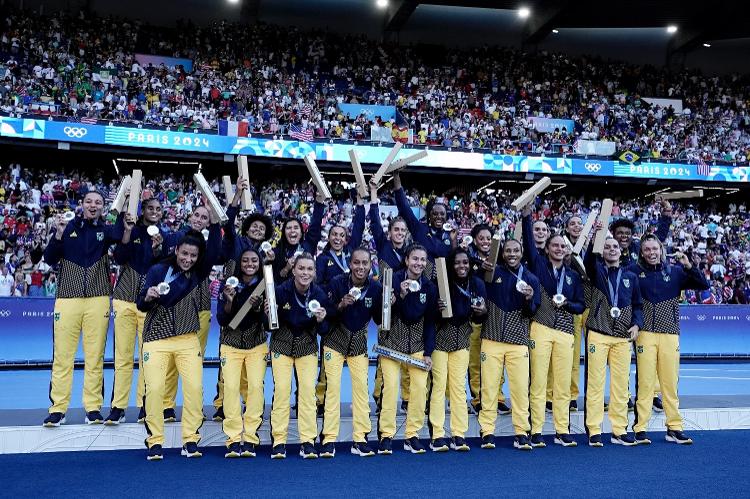 Jogadoras do Brasil acenam no pódio do futebol feminino nas Olimpíadas com a medalha de prata