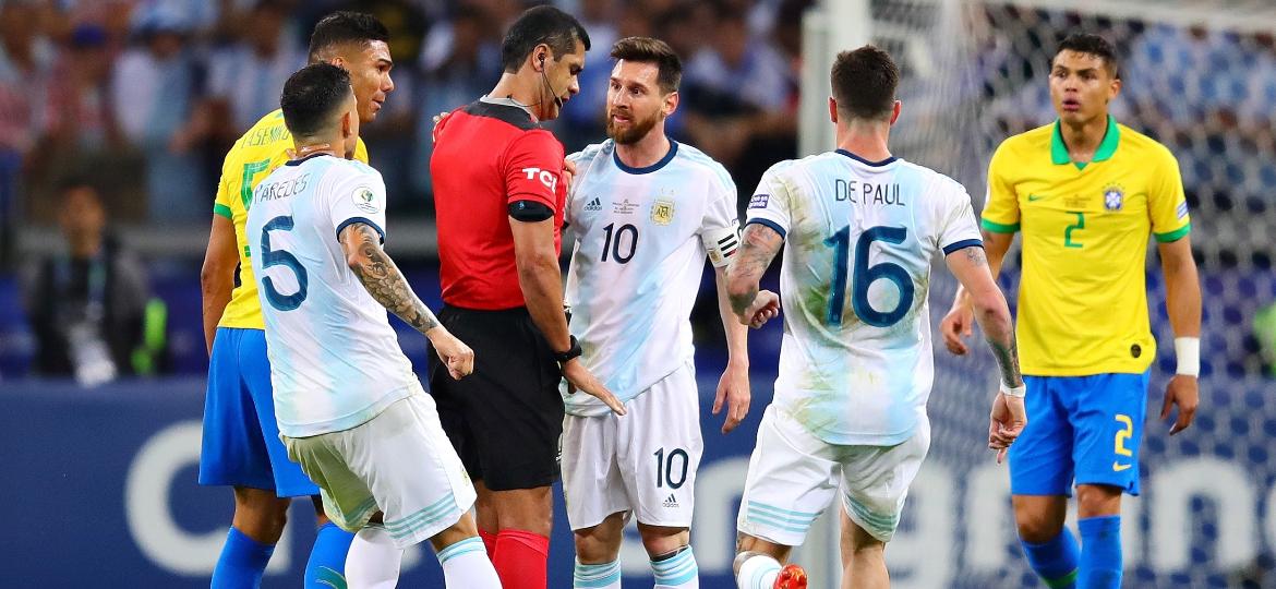 Lionel Messi conversa com o árbitro durante a partida entre Brasil e Argentina - Chris Brunskill/Fantasista/Getty Images