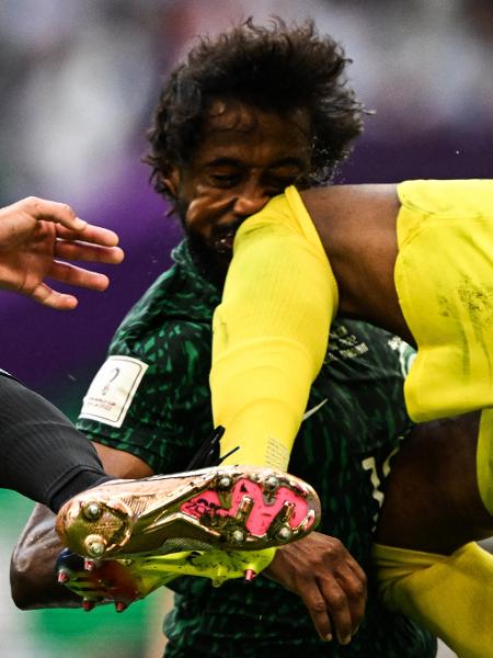 Yasser Al-Shahrani, da Arábia Saudita, no momento em que leva uma joelhada de seu próprio goleiro, Mohammed Al-Owais, durante partida contra a Argentina pela Copa - KIRILL KUDRYAVTSEV / AFP