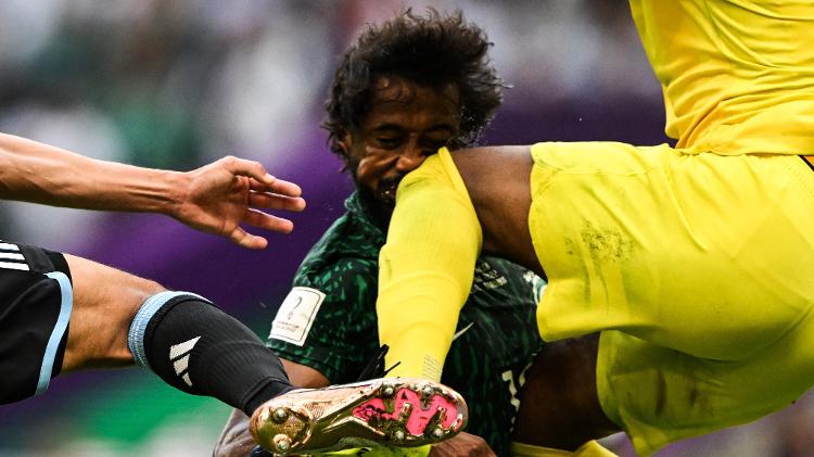 Yasser Al-Shahrani, da Arábia Saudita, no momento em que leva uma joelhada de seu próprio goleiro, Mohammed Al-Owais, durante partida contra a Argentina pela Copa - KIRILL KUDRYAVTSEV / AFP - KIRILL KUDRYAVTSEV / AFP