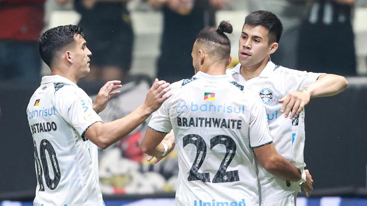 Aravena é abraçado por companheiros após marcar para o Grêmio contra o Atlético-MG