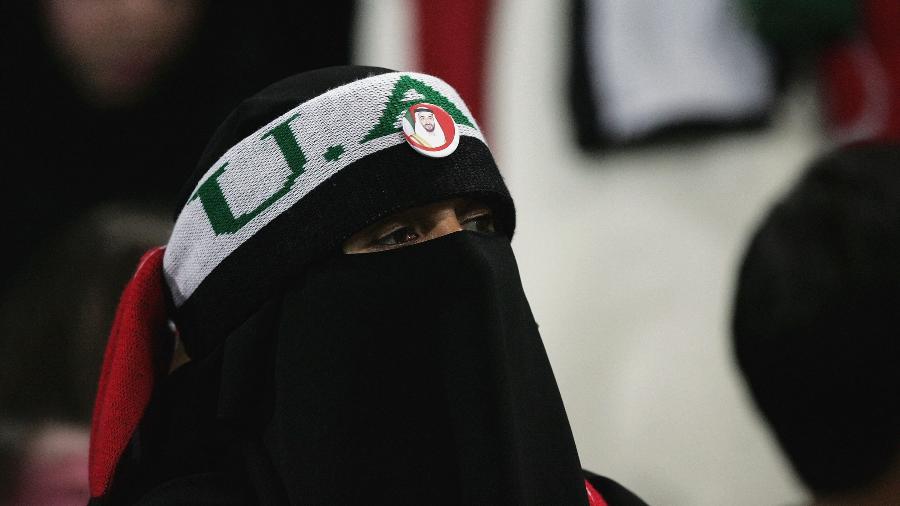 Torcedora com o rosto coberto em partida entre Arábia Saudita e Qatar no Estádio de Al-Jazira, em Abu Dhabi - David Cannon/Getty Images
