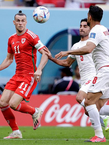 Gareth Bale disputa a bola com dois jogadores iranianos durante a partida entre País de Gales x Irã, na Copa do Mundo - Soccrates Images/Getty Images