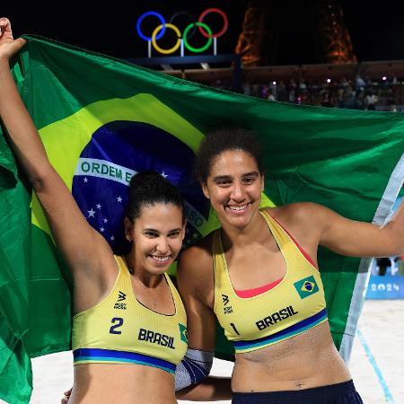 Duda e Ana Patrícia com a bandeira do Brasil após conquistarem o ouro no vôlei de praia nas Olimpíadas de Paris