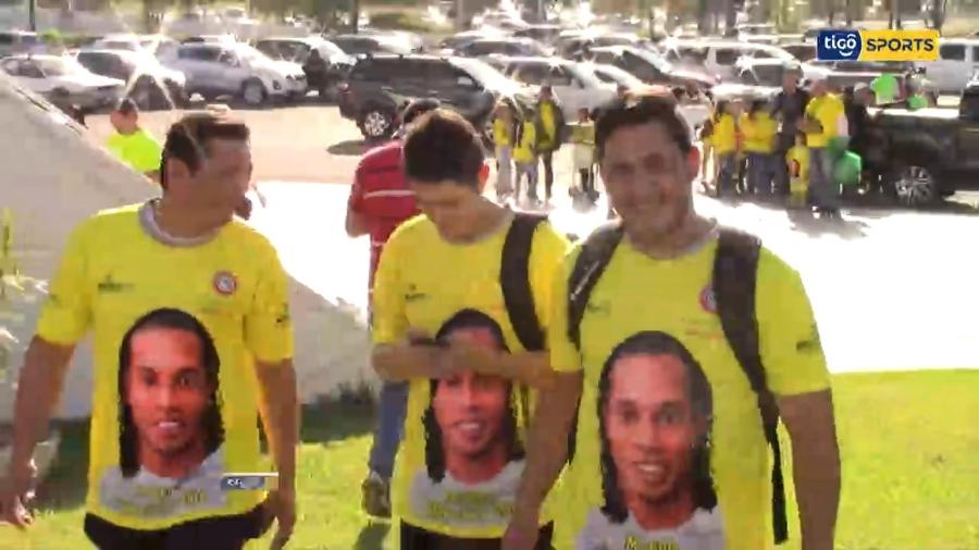 Camisa patrocinada por ONG na chegada de Ronaldinho Gaúcho ao Paraguai é a mesma usada em passaporte falso - Reprodução/Tigo Sports