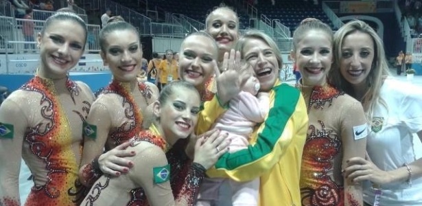 Técnica Camila Ferezin com a filha no colo e a equipe ao seu redor