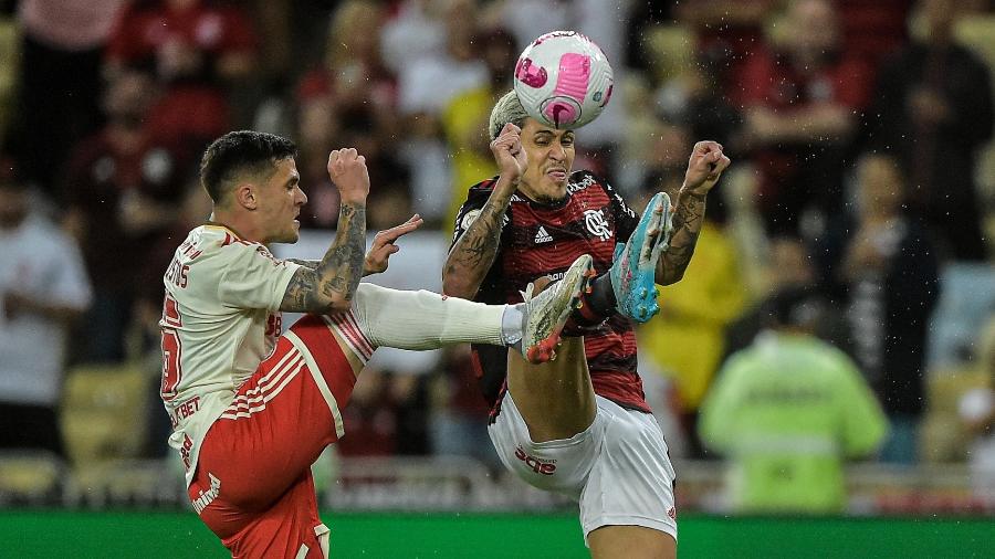 Bustos e Pedro brigam pela bola em Flamengo x Inter, jogo do Campeonato Brasileiro: reencontro