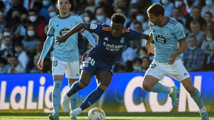 2.4.22 - Vinicius Junior, do Real Madrid, domina a bola entre dois marcadores do Celta de Vigo pelo Campeonato Espanhol - MIGUEL RIOPA/AFP