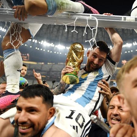 Messi é carregado por Aguero com a Taça da Copa, enquanto torcedores cortam redes do estádio Lusail - Divulgação/Fifa
