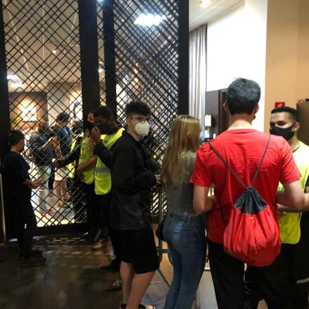 Los invitados intentan ver a los jugadores argentinos a través de la puerta de la cocina de un hotel en Guayaquil - Bruno Bros / UOL Esporte - Bruno Bros / UOL Esports