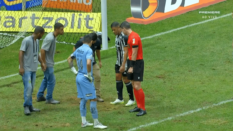 Funcionários da Arena MRV fazendo manutenção no campo durante o jogo