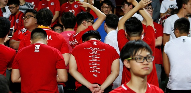 De costas para o campo, torcedores de Hong Kong protestam durante hino chinês - Bobby Yip/Reuters