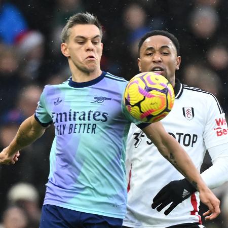 Leandro Trossard (à esq.), meia do Arsenal, é marcado pelo zagueiro Kenny Tete, do Fulham, em jogo pelo Inglês - JUSTIN TALLIS/AFP