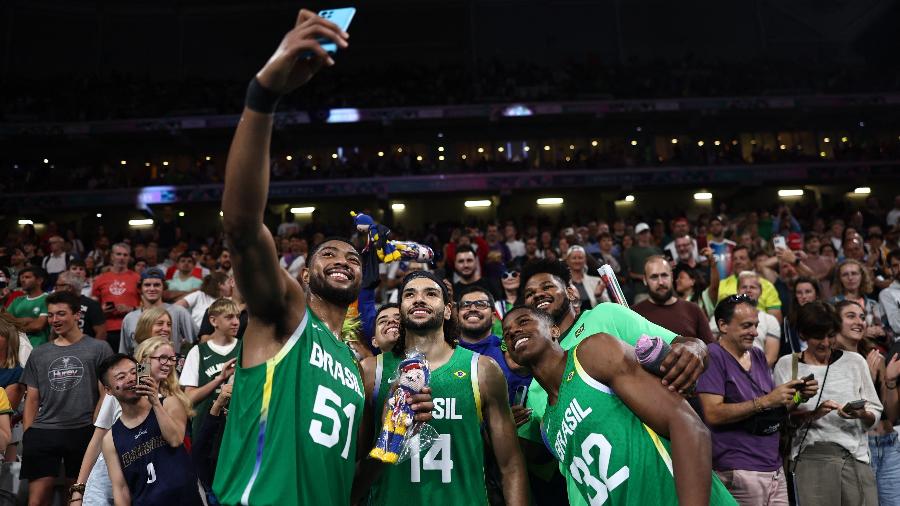 Jogadores da seleção brasileira de basquete tirando selfie após vitória sobre o Japão nas Olimpíadas