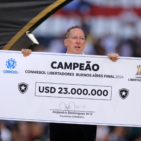 John Textor posa com cheque simbólico da premiação pela conquista da Libertadores 2024