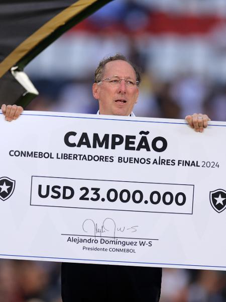 John Textor posa com cheque simbólico da premiação pela conquista da Libertadores 2024