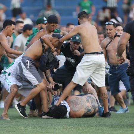 Torcedores de Coritiba e Cruzeiro brigando em campo no jogo do Brasileirão Torcedores de Coritiba e Cruzeiro brigando em campo no jogo do Brasileirão